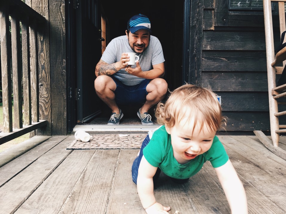 Son crawling with dad watching