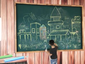 Kid drawing on chalkboard