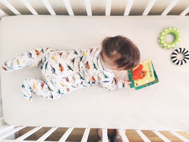 Baby in crib with book