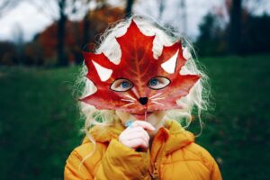 Child holing leaf up to face