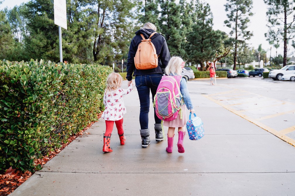 adult walking two children to school