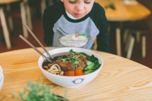 Child examining bowl of food