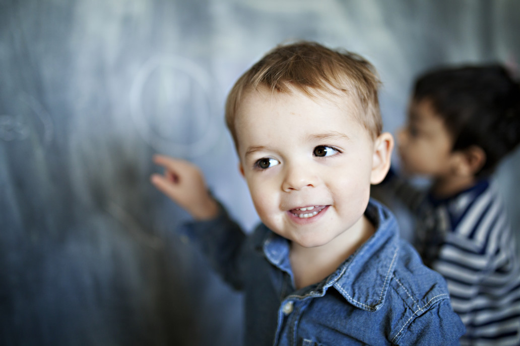 Toddler writing on chalkboard