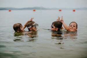 Kids playing in a lake.