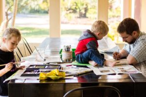 Kids painting at a table with dad.