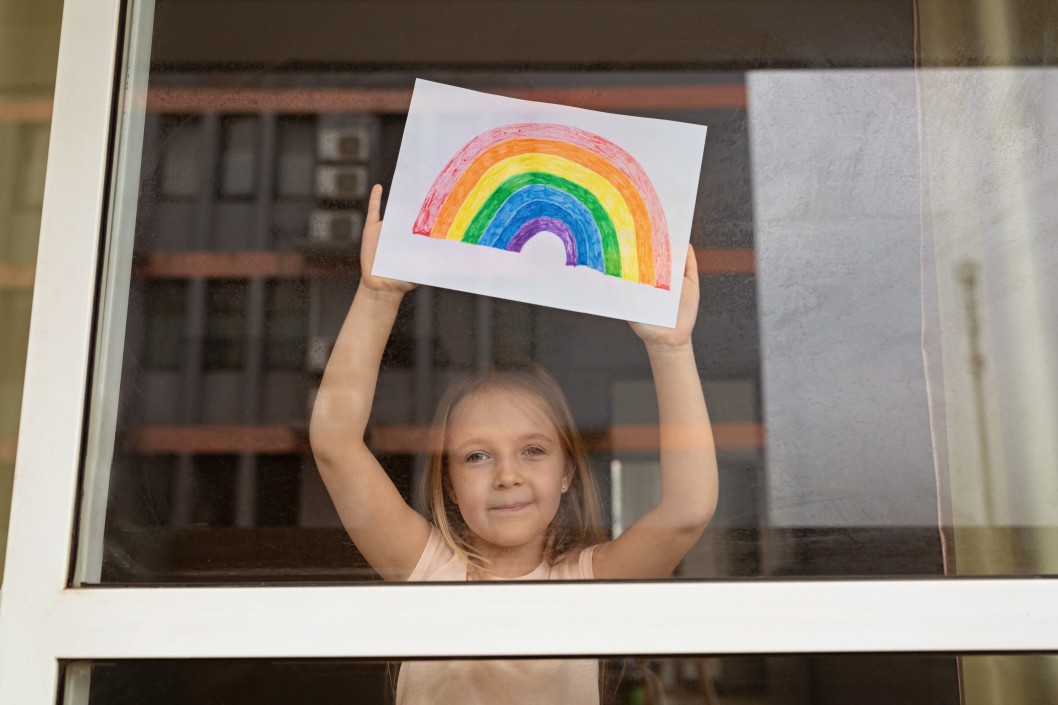 Child with rainbow drawing