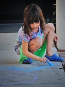 Child coloring with chalk
