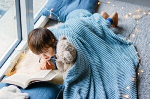 Child reading to teddy bear