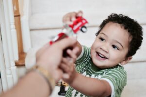 Child playing with a toy firetruck.