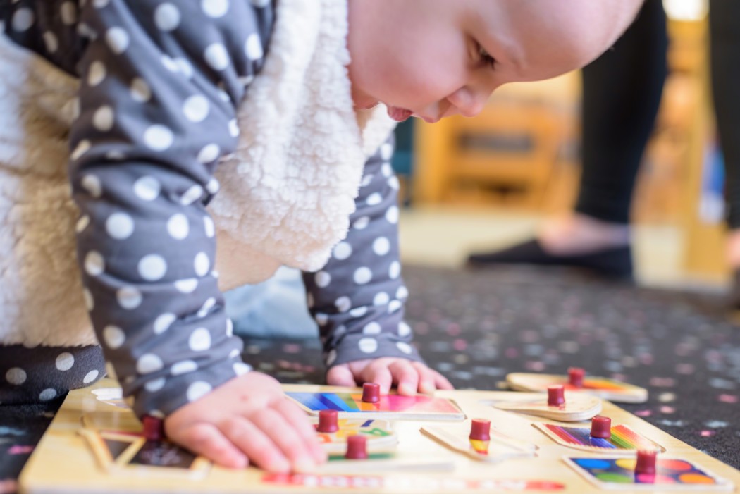 a baby hovering over a puzzle