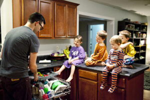 Dad teaching kids to do chores.