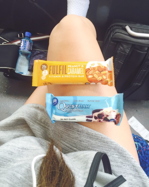 Busy mom eats protein bar on the go.