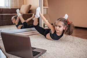 Little girl doing yoga on the floor.