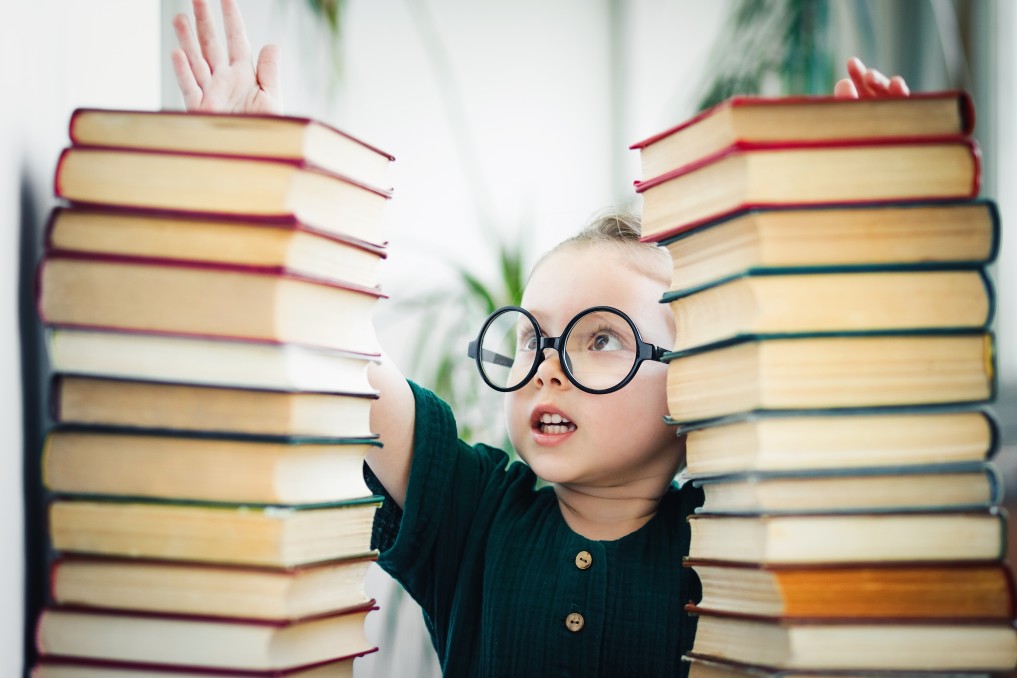 Boy next to stacks of books.