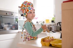 Little girl cooking in a kitchen.