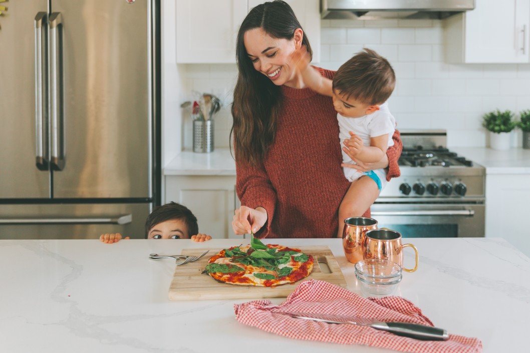 Mom making dinner with kids.