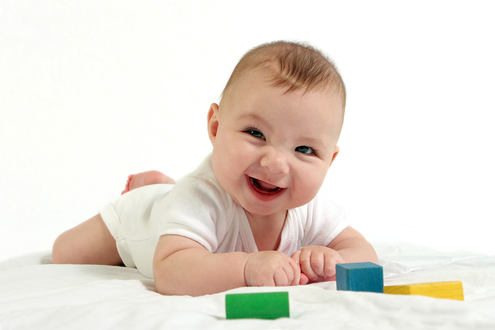 Infant having tummy time with block toys to encourage gross motor development