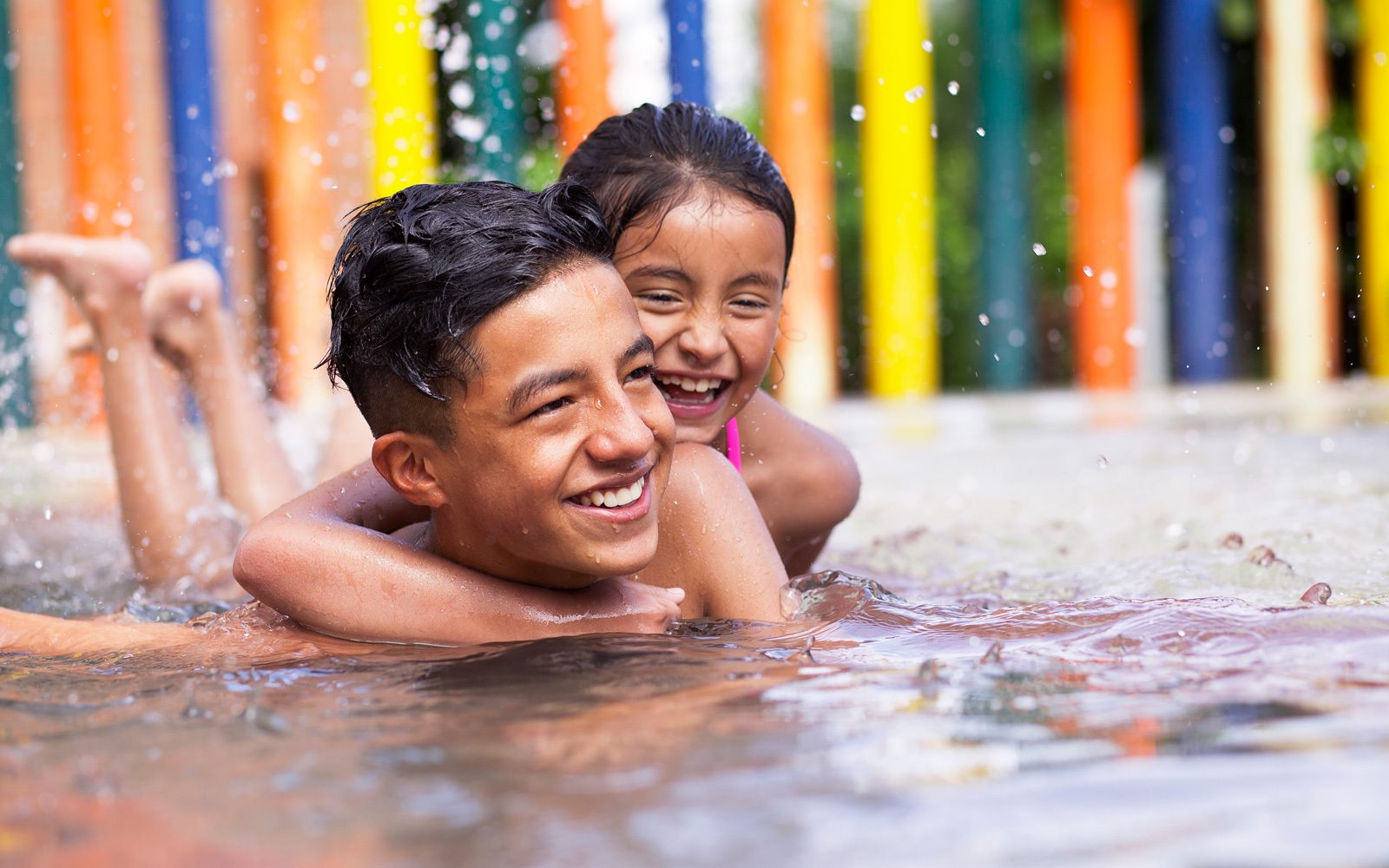 Siblings playing in a splash pad