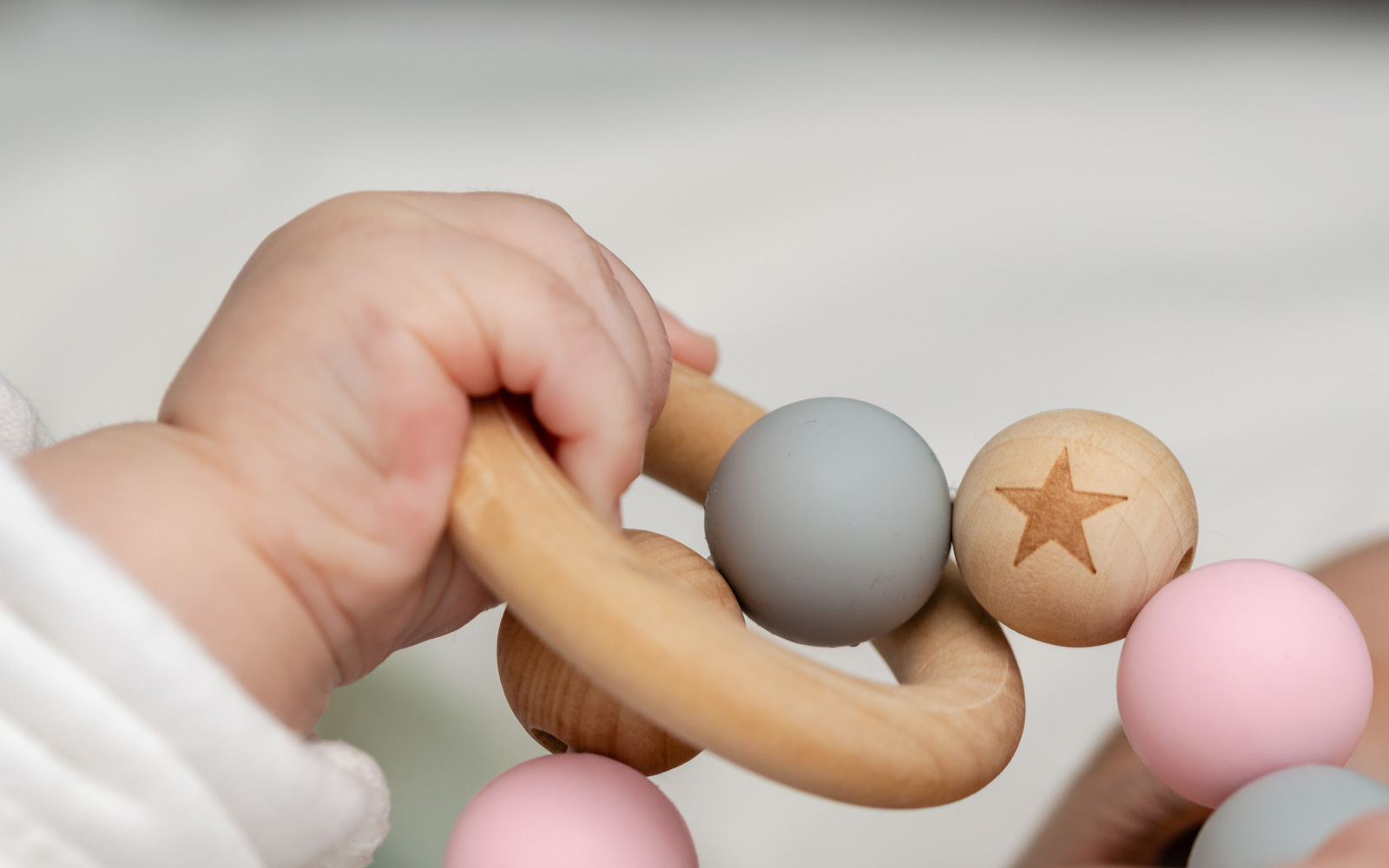 Baby holds a wooden toy