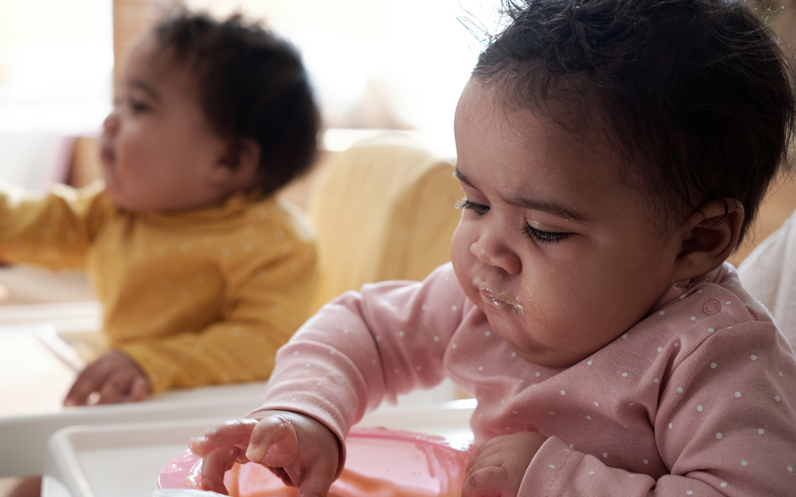 Young children eating in high chairs
