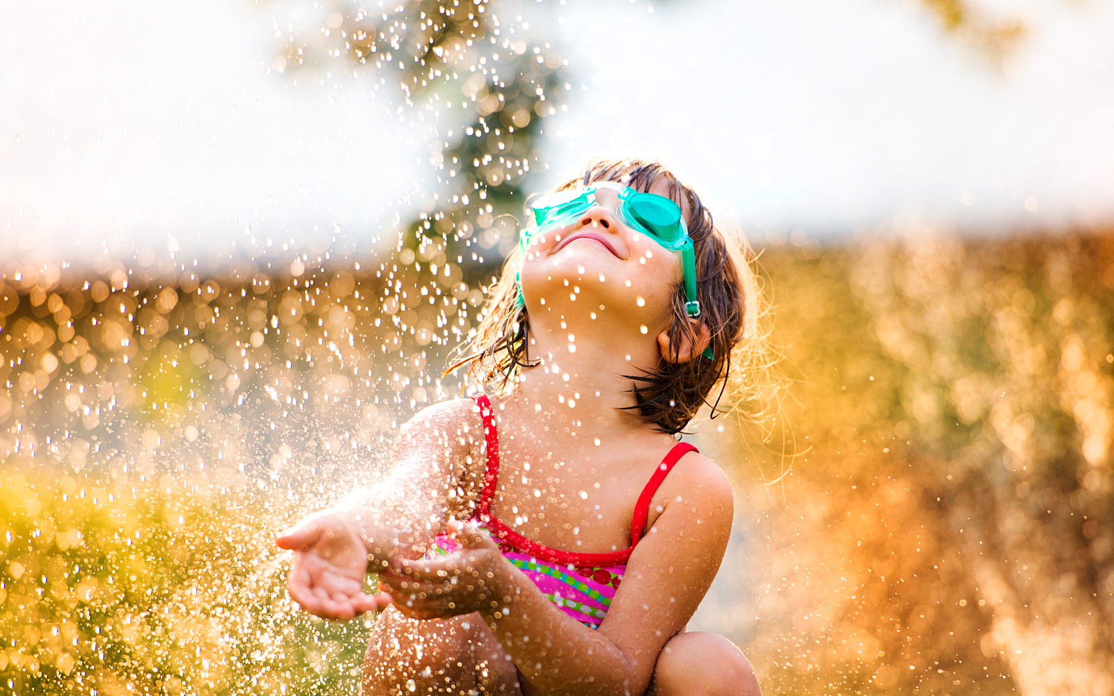 Child playing in sprinkler