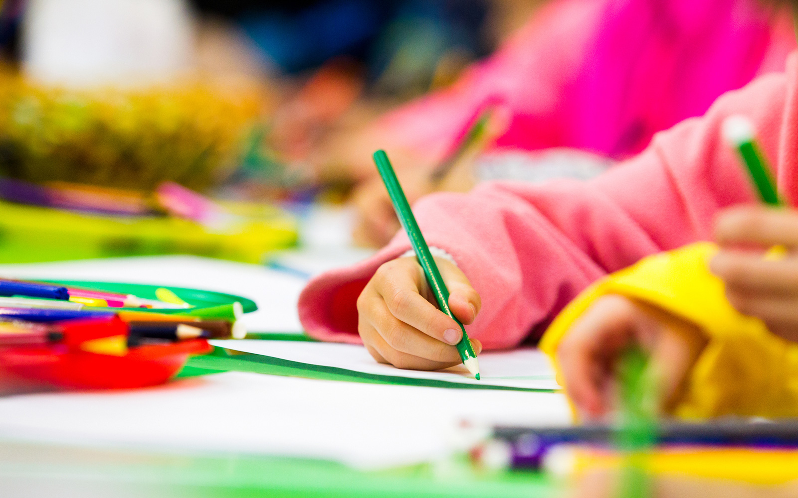 Preschool Age Child writing with colored pencil