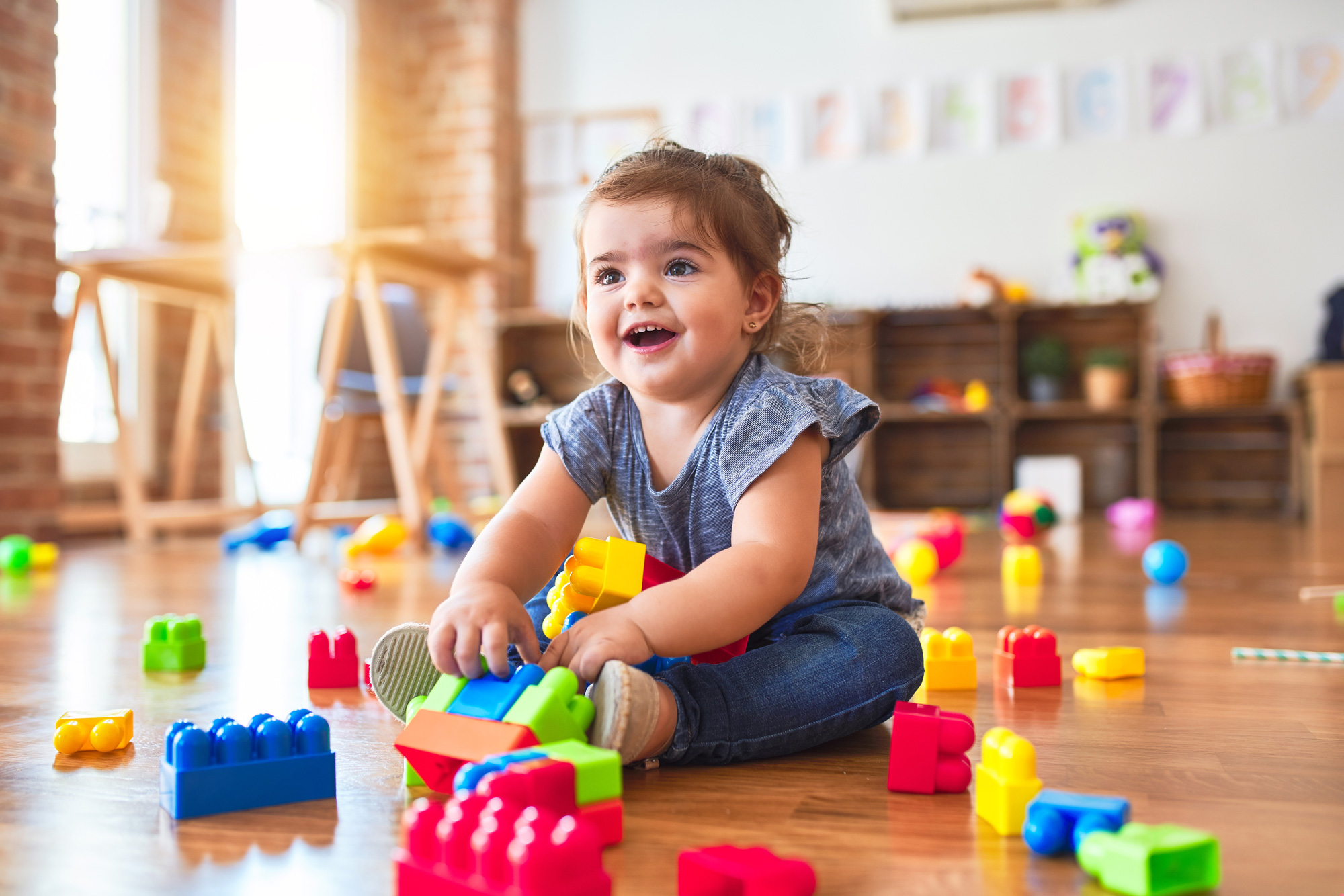 Small child plays with colorful toys