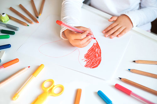 Toddler Draws and Colors a Heart on Paper