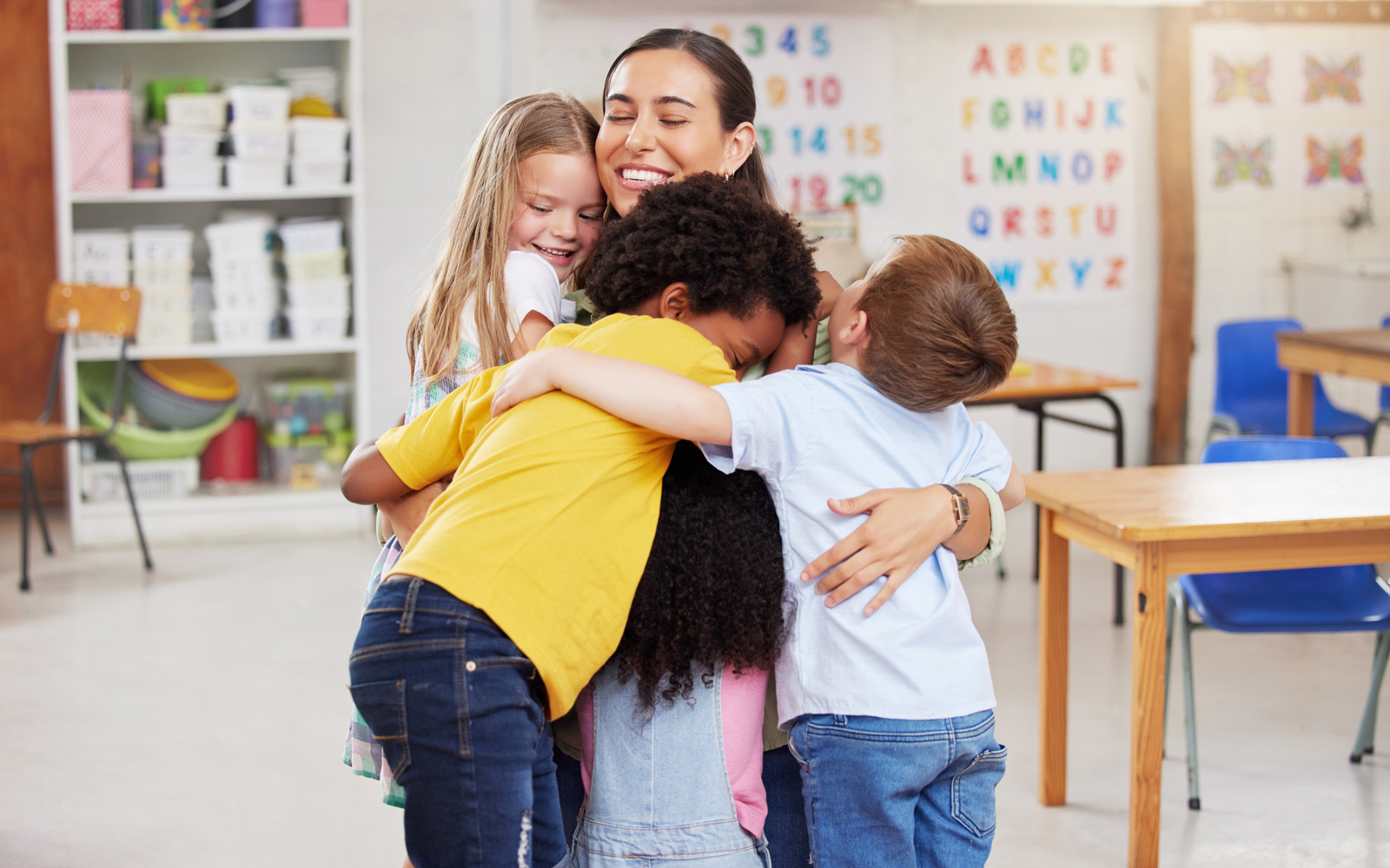 Preschool Teacher Hugs Students