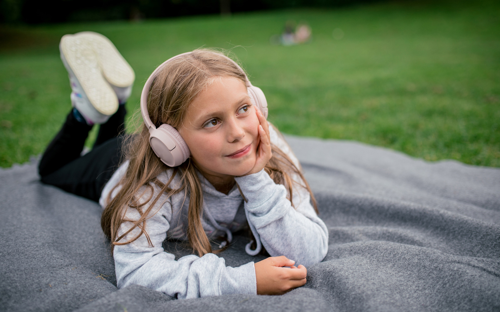 Girl Listens to a Podcast on a Picnic Blanket