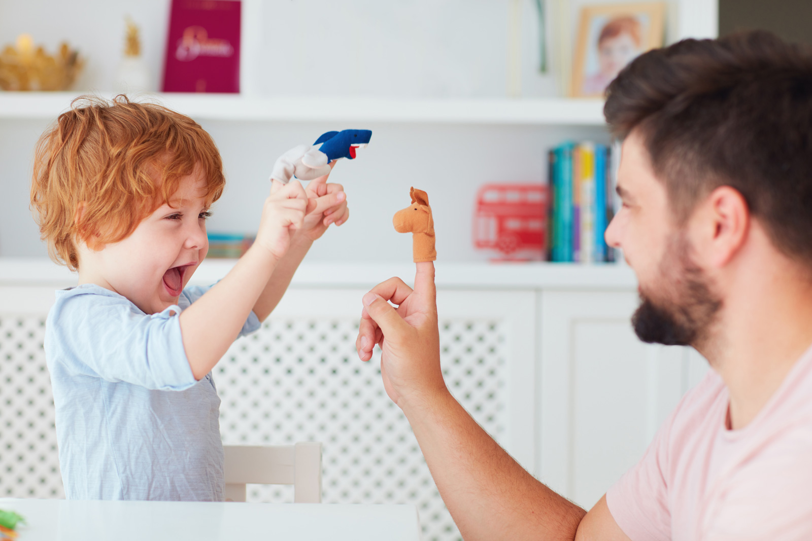 Dad and child play with finger puppets