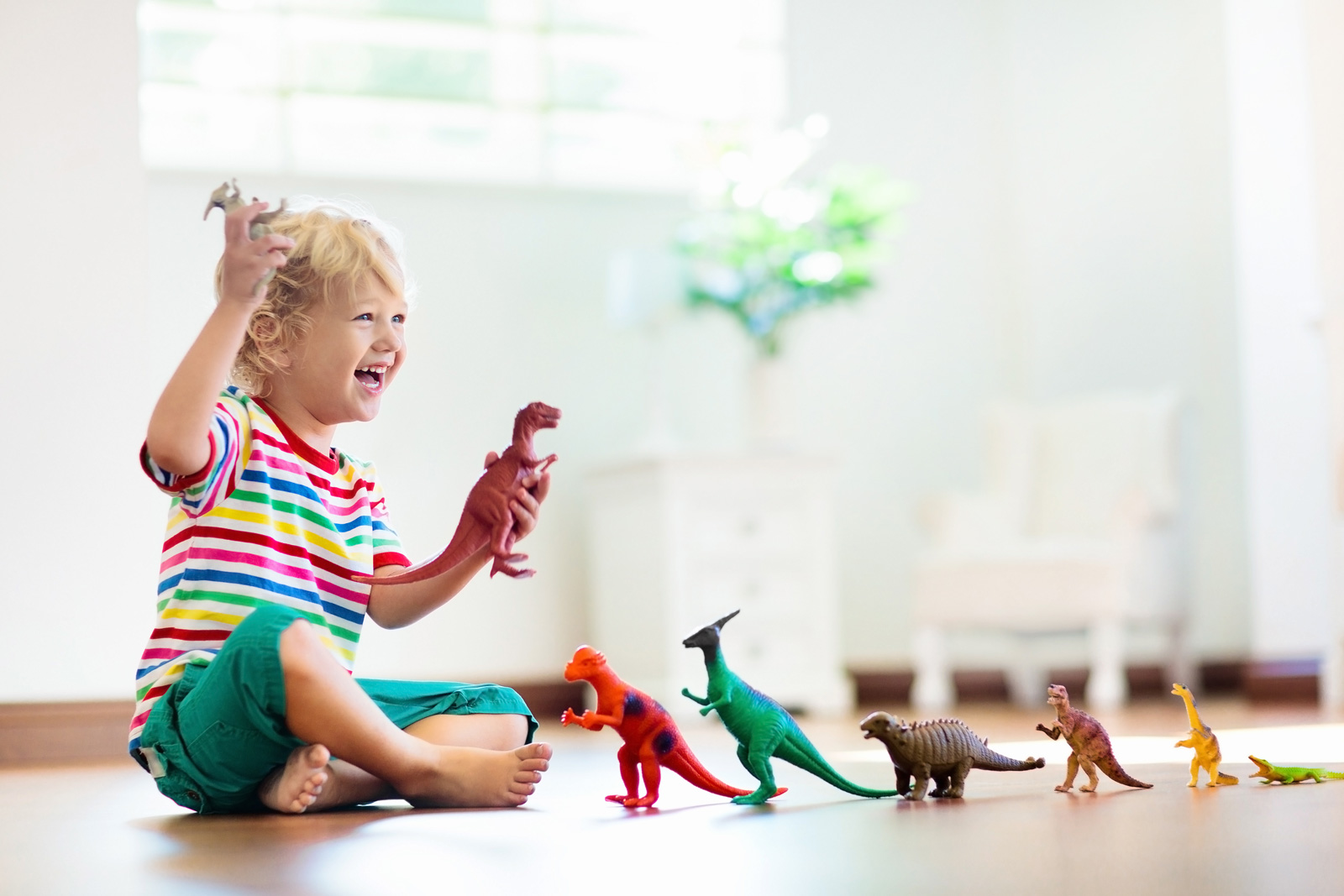 Child plays with dinosaur toys