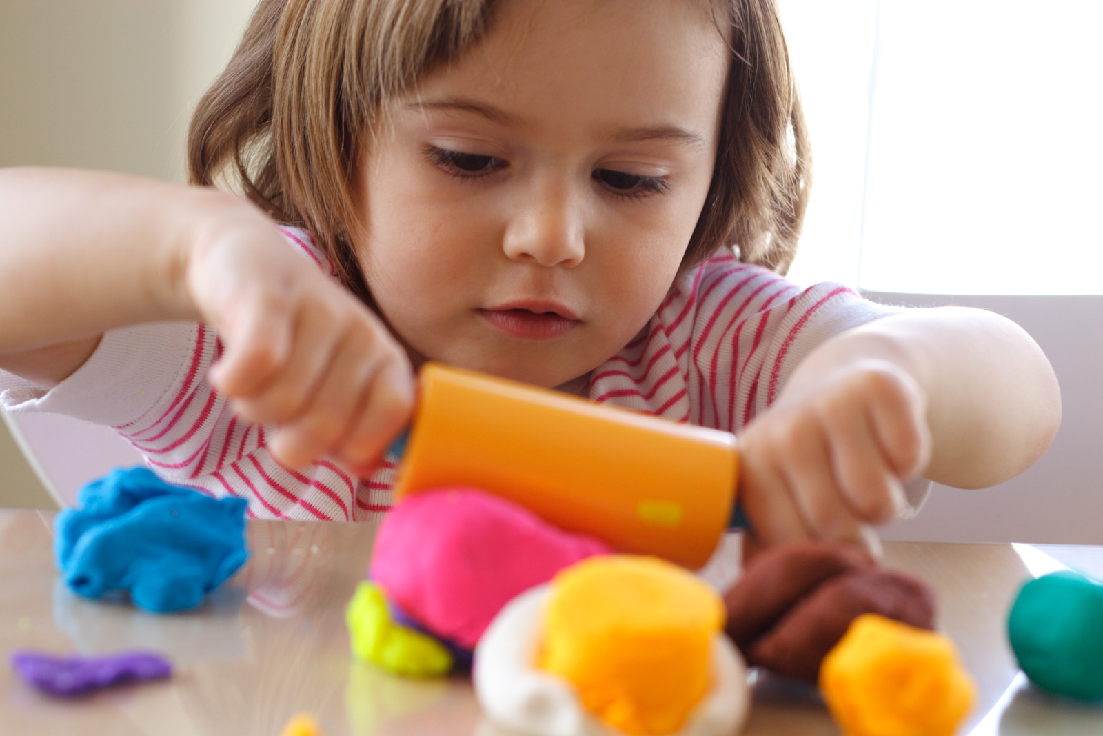 Toddler rolls out Play Doh