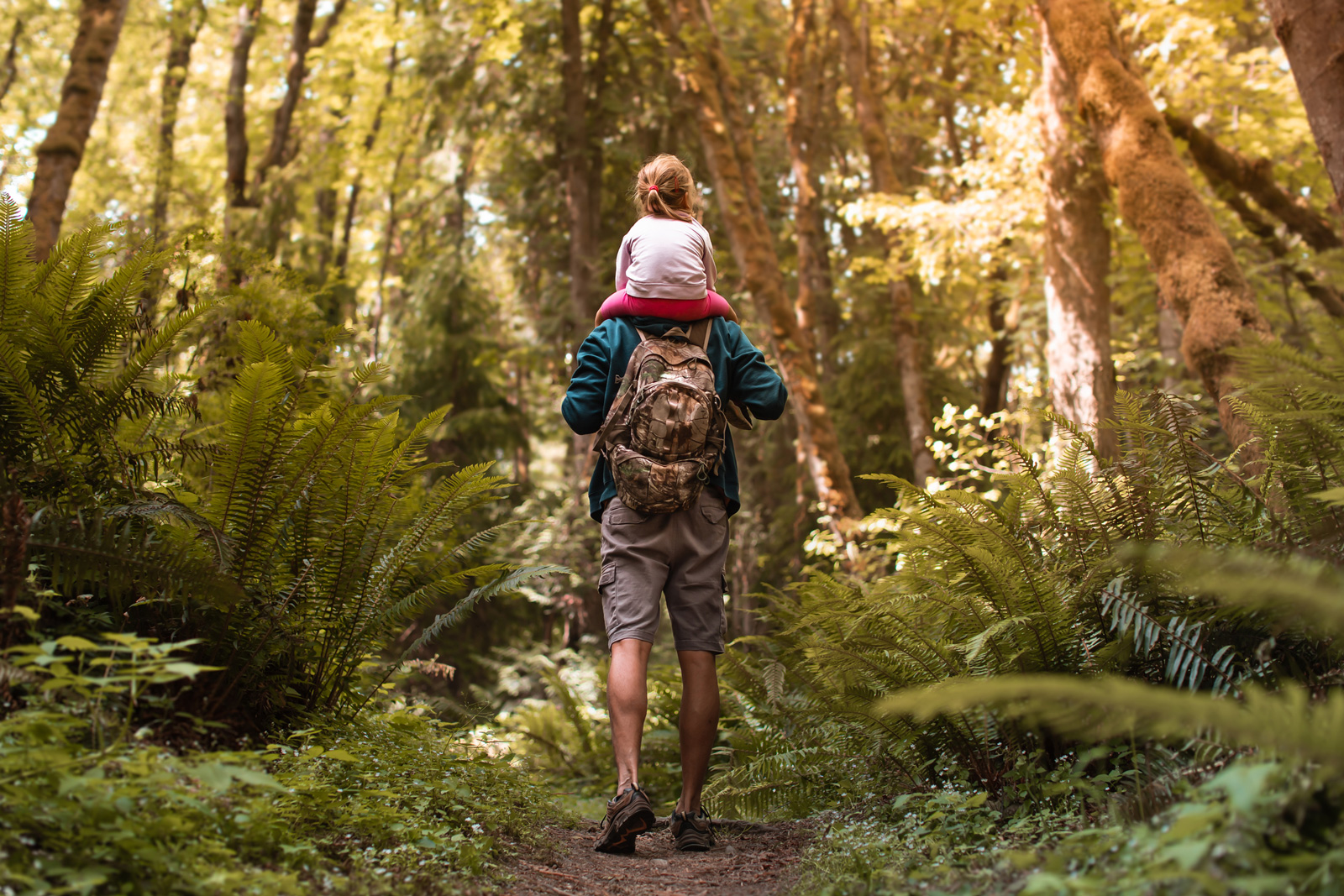 Man hiking with child on her shoulders